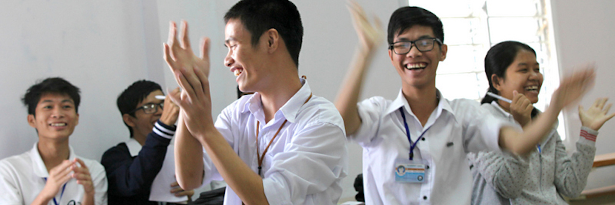 PNV group of students in a classroom clapping and smiling.