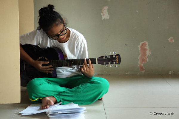 Etudiante de PNP joue de la guitare dans le centre.
