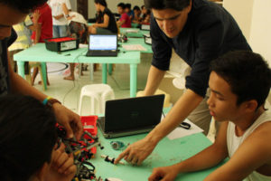 Fabrice Filachet aux côtés d'étudiants, travaillant avec des Lego Mindstorm