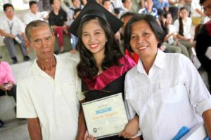 Une jeune diplômée avec ses parents montrant leur fierté