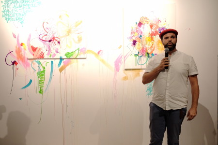 Lyes Olivier Sidhoum in front on his artwork